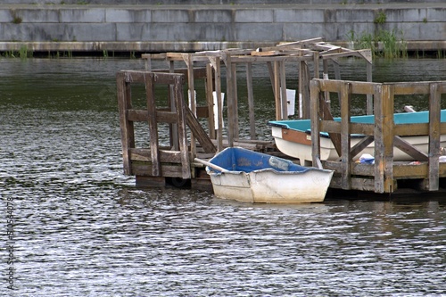 An old boat is parked at the village river pier on a summer day