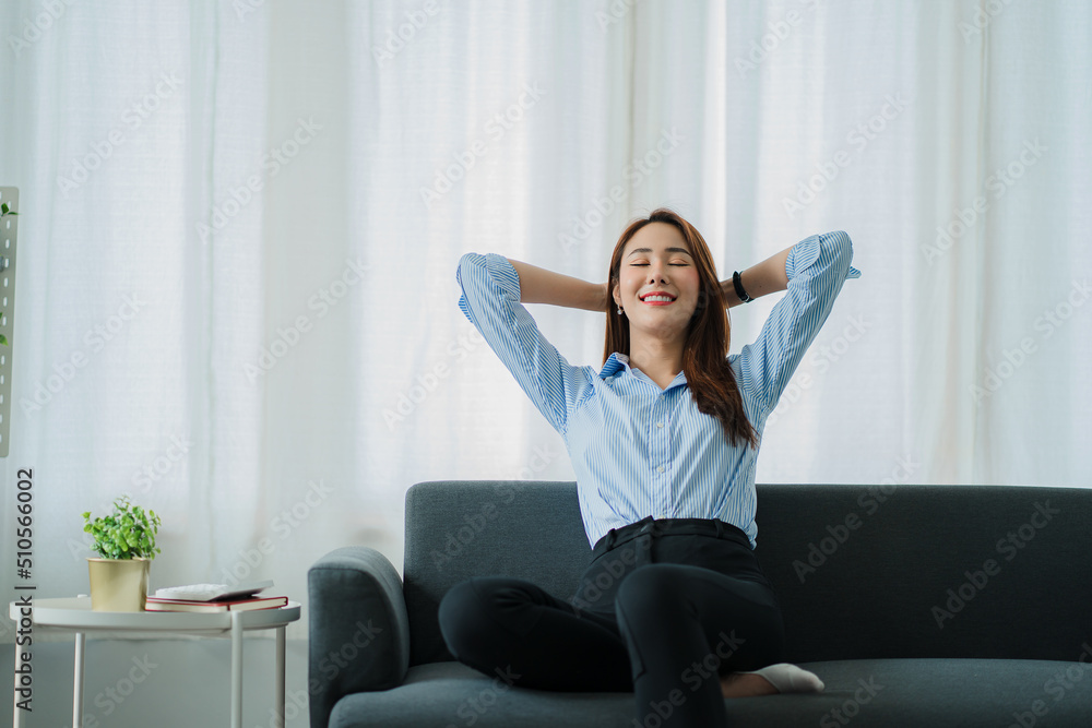 smiling asian woman relaxing sitting on sofa at home Relaxed lifestyle woman enjoying luxury sofa on living room. smiling asian woman relaxing sitting on sofa at home Relaxed lifestyle woman enjoying luxury sofa on living room.