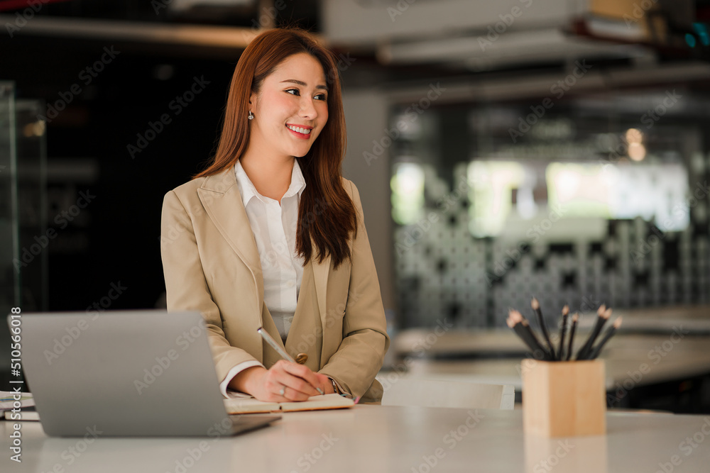 Asian businesswoman working on laptop computer in office with documents on desk woman looking at financial statistics data analysis chart profit growth business idea vertical image Asian businesswoman working on laptop computer in office with documents on desk woman looking at financial statistics data analysis chart profit growth business idea vertical image