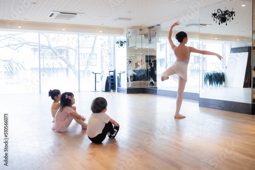 見本のダンスを見て学ぶ子供のバレエダンサー