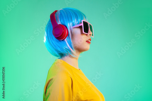 young asian women in headphones isolated on neon green backgrounds. Human emotions.