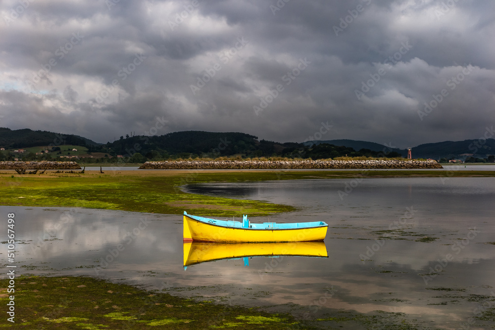 Fototapeta premium small yellow fishing boat moored in the marsh
