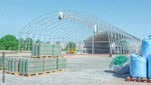 Static shot of metal frame of a building under construction in timelapse. Blue sky on a background photo