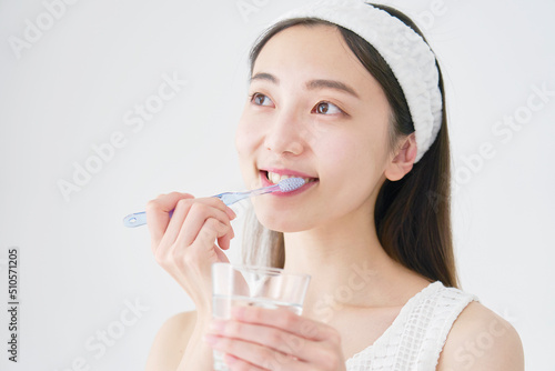 白バックで歯磨きする女性