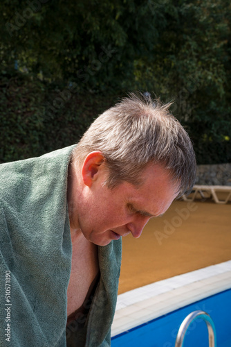 An elderly gray-haired retired man swims in the pool. The concept of a healthy active lifestyle in old age