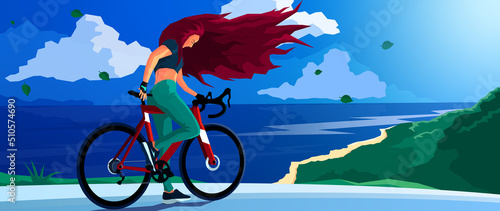 A cyclist. A girl on a bicycle. Road bike. Gravel bike. I'm blowing my red hair in the wind. journey. Mountains, beach, road, sea, ocean on the background. Blue sky. Midday.