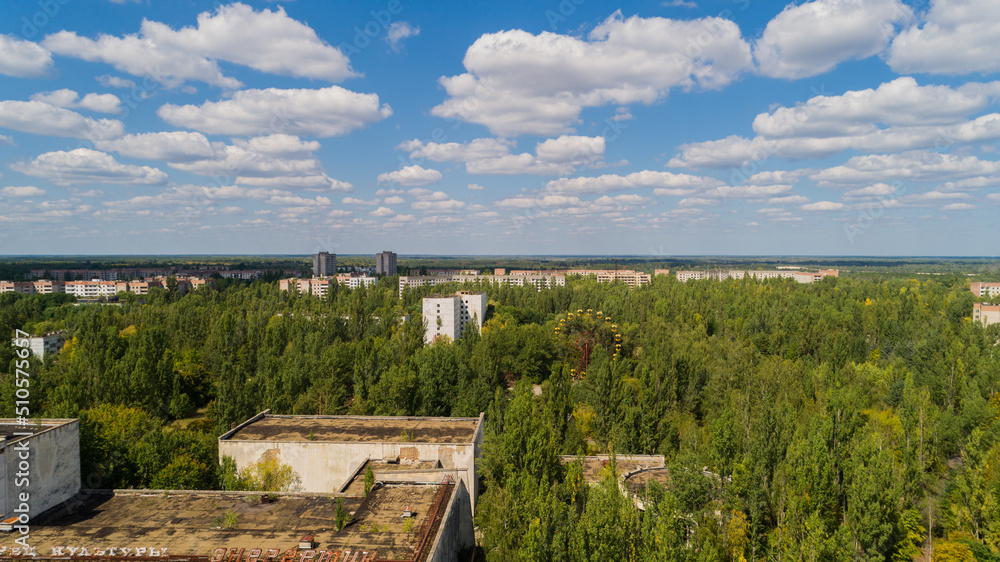 Aerial view abandoned buildings and streets overgrown with trees in city Pripyat near Chernobyl nuclear power plant. Drone shot Exclusion Zone in summer. Radiation Aerial view abandoned buildings and streets overgrown with trees in city Pripyat near Chernobyl nuclear power plant. Drone shot Exclusion Zone in summer. Radiation