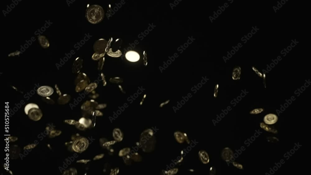 Many gold coins tossed up in the air and falling in slow motion Many gold coins tossed up in the air and falling in slow motion