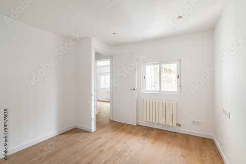 Empty room with window and hardwood floor after renovation. New apartment for rent or sale.