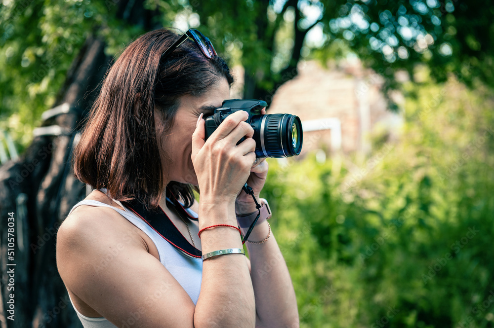 Young woman with a camera taking pictures outdoor. Young woman with a camera taking pictures outdoor.