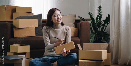 Starting small businesses SME owners female entrepreneurs Write the address on receipt box and check online orders to prepare to pack the boxes, sell to customers, sme business ideas online. © wichayada