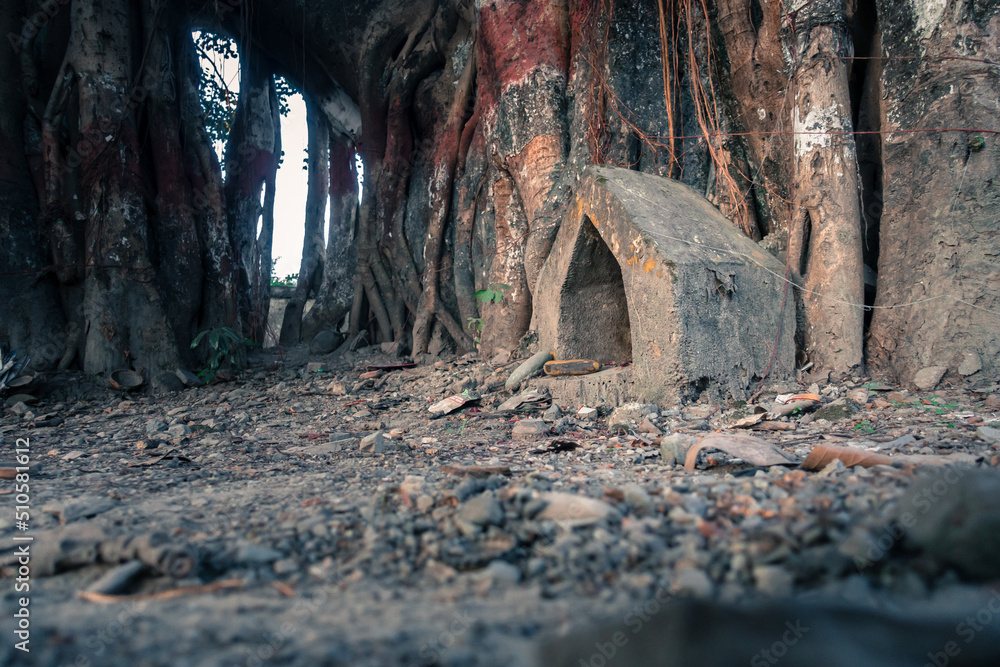 A small triangular prayer spot of Hindu deity under a banyan tree. Dehradun Uttarakhand India. These small triangular monument are very common in Hindu Religion as a worship place . A small triangular prayer spot of Hindu deity under a banyan tree. Dehradun Uttarakhand India. These small triangular monument are very common in Hindu Religion as a worship place .