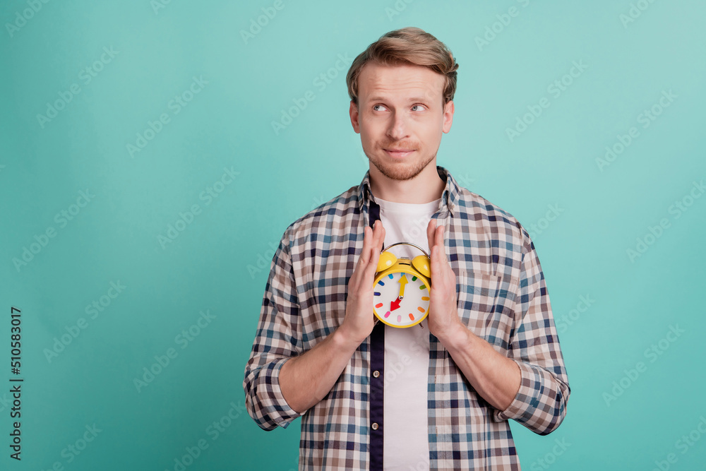 Curious minded thoughtful guy hold alarm clock look empty space think ideas contemplate punctuality Curious minded thoughtful guy hold alarm clock look empty space think ideas contemplate punctuality