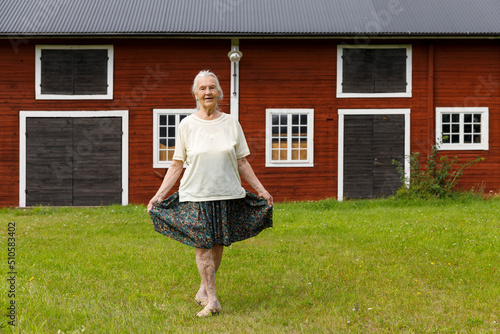 Fotografering Senior woman doing curtsy by house