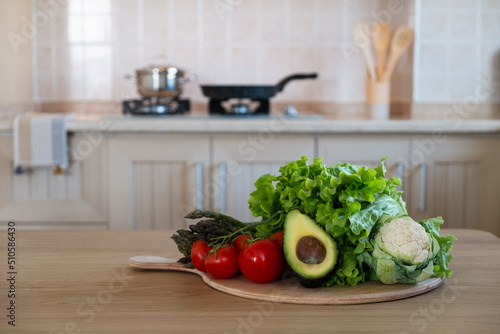 Bunch of different raw organic fruits, vegetables and greens lying in pile on a chopping board. Kitchen table with groceries. Close up, copy space for text, interior background.