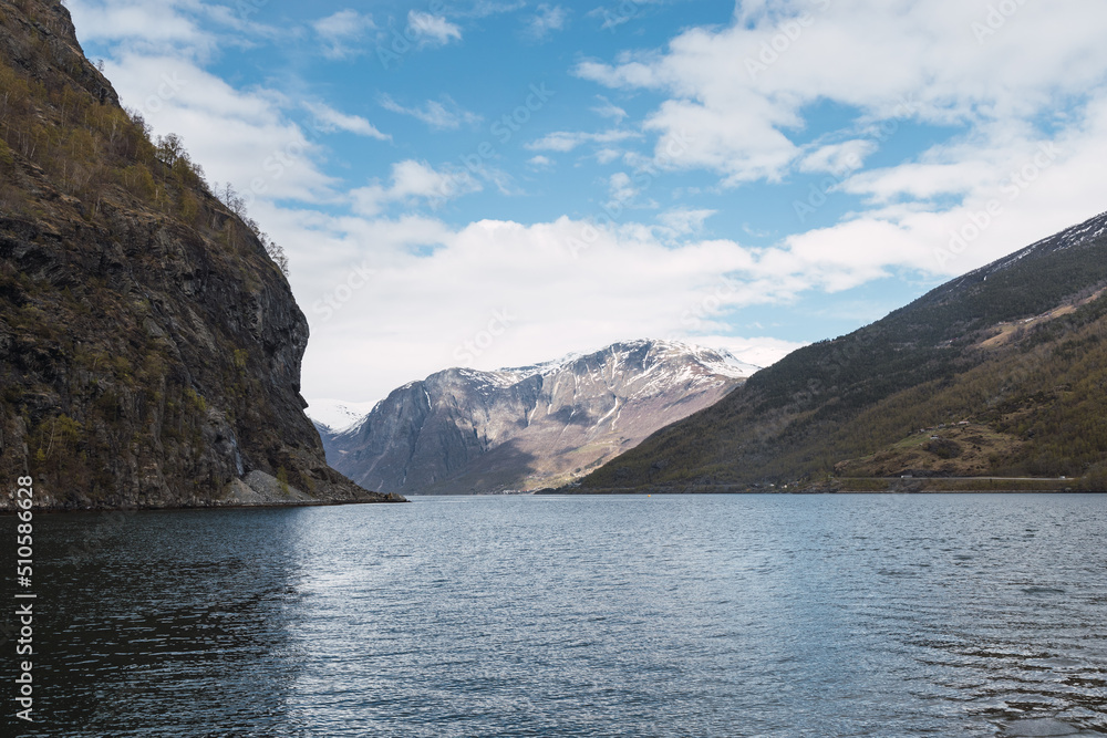 Views of a fjord between mountains with a large snow-capped mountain in the background. Views of a fjord between mountains with a large snow-capped mountain in the background.