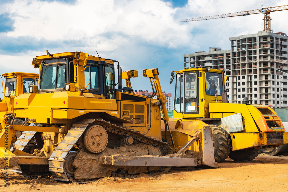 Bulldozer machine is leveling construction site. Earthmover with sky background. close-up. construction heavy machinery.