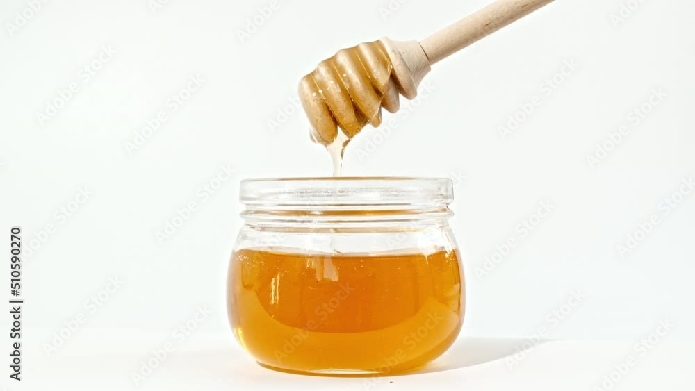 Honey Dripping, Pouring from Special Honey Spoon in Glass Bowl. Honey Dripping Isolated on White Background. Healthy Food Concept. High quality 4k footage Honey Dripping, Pouring from Special Honey Spoon in Glass Bowl. Honey Dripping Isolated on White Background. Healthy Food Concept. High quality 4k footage