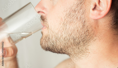 Fototapeta Naklejka Na Ścianę i Meble -  bearded man drinks water from a glass
