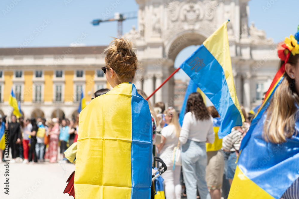 Portugal, Lisbon April 2022: The demonstration on Commerce Square in support of Ukraine and against the Russian aggression. Protesters against Russia's war Many people with Ukrainian flags.
