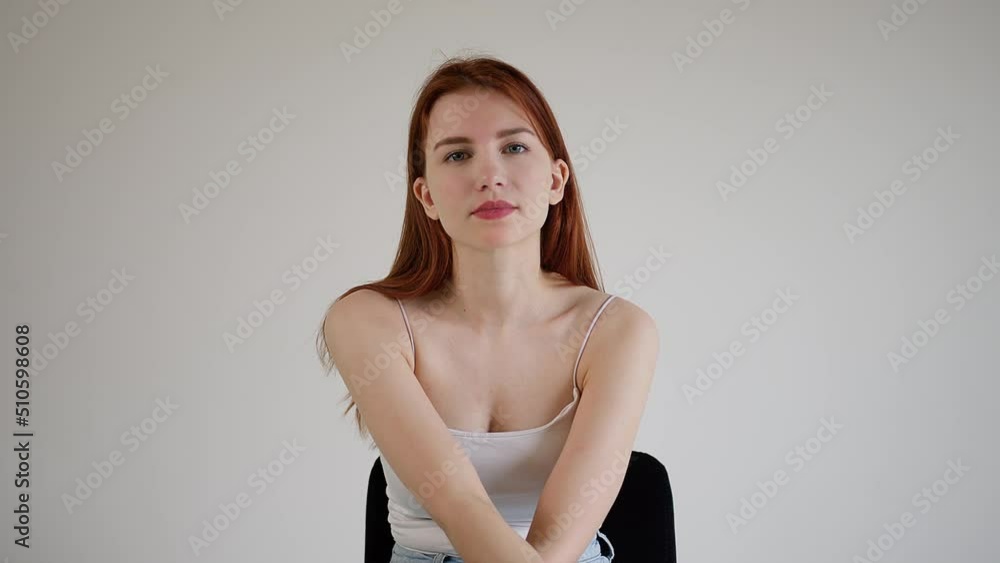 Beautiful young woman carefully looks into the camera Beautiful young woman carefully looks into the camera