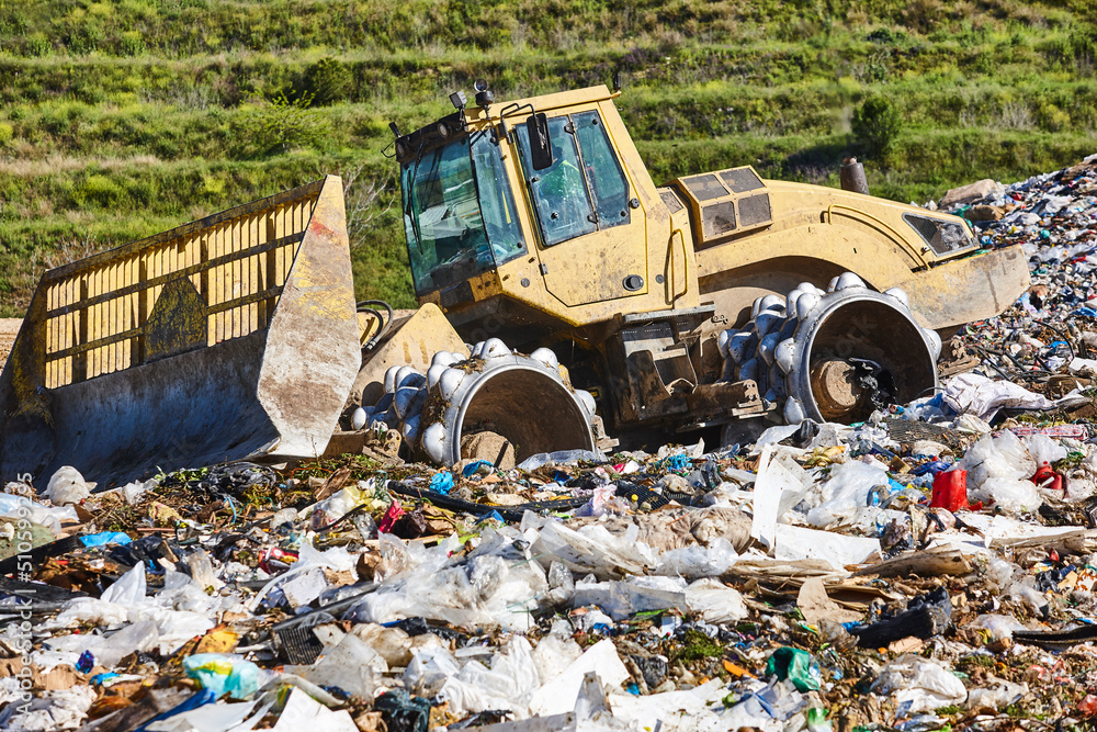 Heavy machinery shredding garbage in an open air landfill. Waste Heavy machinery shredding garbage in an open air landfill. Waste