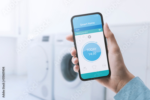Woman controlling her washing machine from her phone
