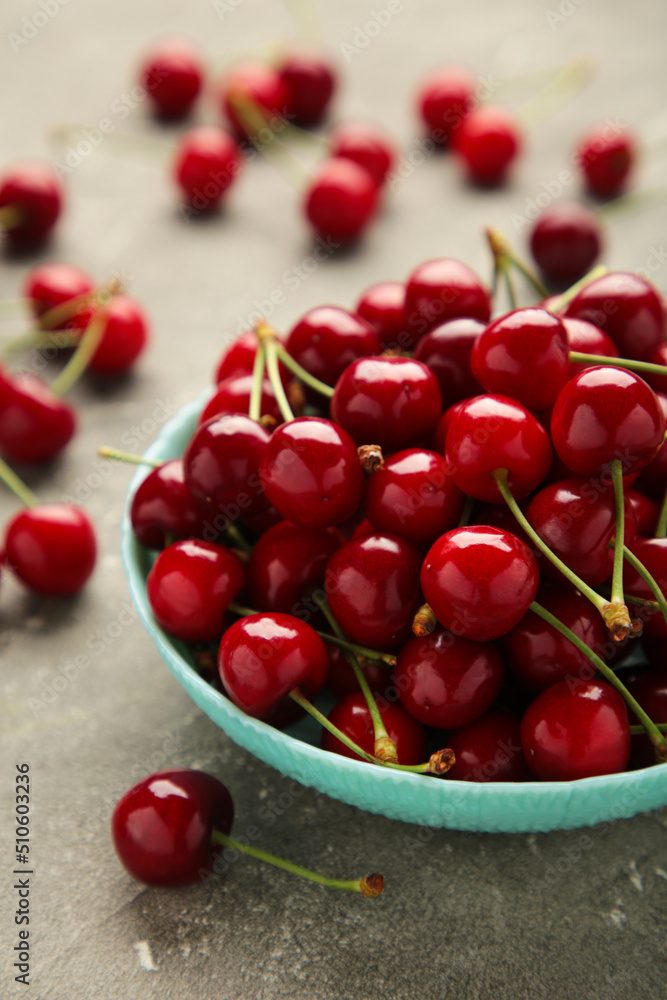 Fresh sweet cherries bowl on grey background, top view Fresh sweet cherries bowl on grey background, top view