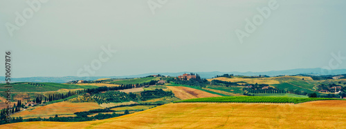 Traditional countryside and landscapes of beautiful Tuscany. Fields in golden colors and cypresses. Holiday  traveling concept. Agro tour of Europe. Vintage tone filter effect with noise and grain.