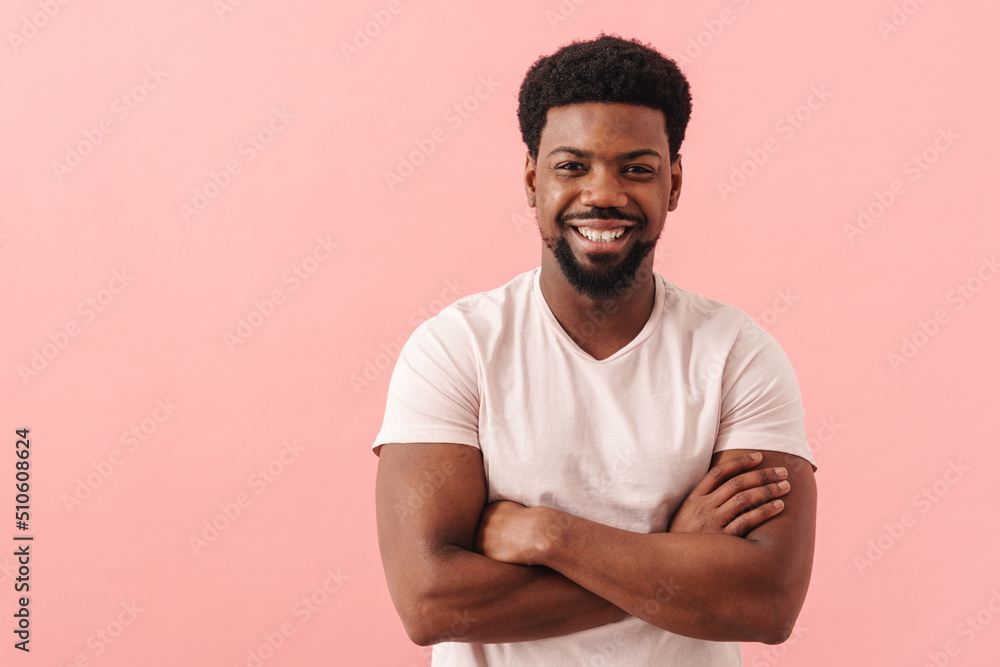 Black mid man smiling while posing with arms crossed Black mid man smiling while posing with arms crossed