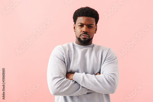 Black displeased man posing with arms crossed at camera
