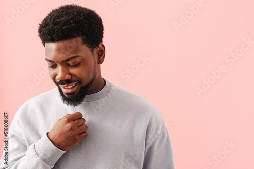 Black mid man with beard smiling and looking downward