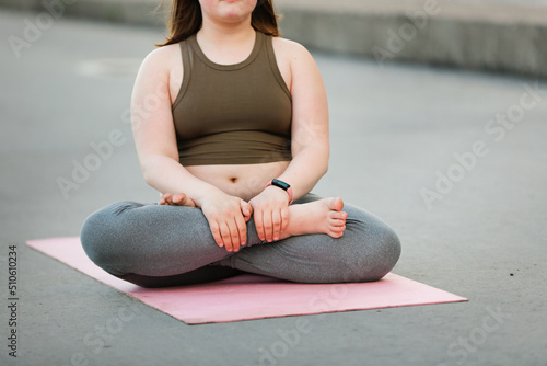 Εκτύπωση καμβά Girl child teenager with excess weight does yoga exercises on mat on concrete pa