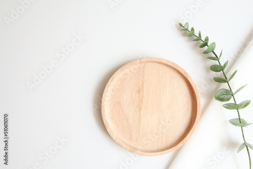 wooden tray and white fabric background for cosmetic products. top view, copy space.