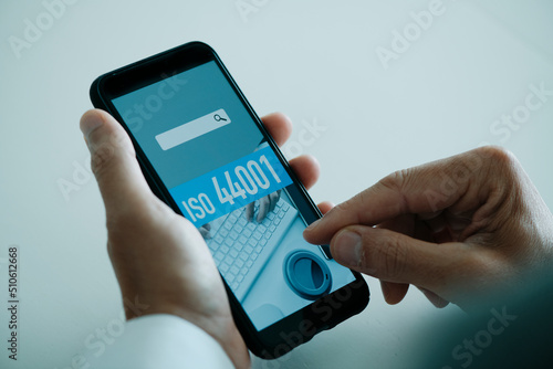 the text ISO 44001 in the screen of his smartphone