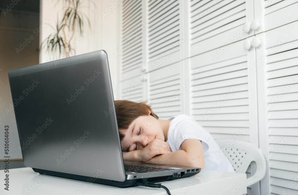 Little boy fell asleep on the laptop. Child lay with closed eyes and sleeps. Tired pupil. Difficult, boring, long study program. Hard task. Early morning lesson. Avitaminosis - vitamin deficiency Little boy fell asleep on the laptop. Child lay with closed eyes and sleeps. Tired pupil. Difficult, boring, long study program. Hard task. Early morning lesson. Avitaminosis - vitamin deficiency