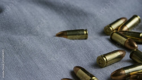 9mm pistol bullets resting on a cloth and camera spinning around. photo