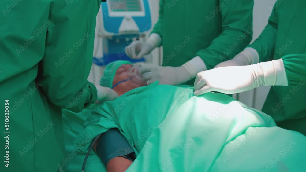 Professional operating doctor and nurse in team help to put oxygen mask to patient before start process of operation in room for treatment in hospital. Professional operating doctor and nurse in team help to put oxygen mask to patient before start process of operation in room for treatment in hospital.