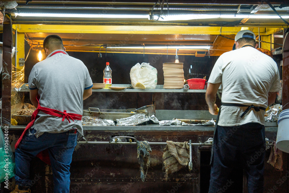Open air Mexican taqueria Street food Restaurant Where two Mexicans are making tacos and quesadillas