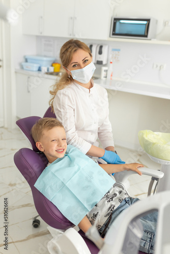 Dentist examining little boy s teeth in modern clinic