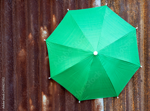 A close-up view of the top background of a large green tarpaulin umbrella.