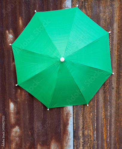 A close-up view of the top background of a large green tarpaulin umbrella. photo