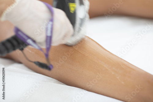 Hair removal procedure. Laser epilation, cosmetology, spa, and hair removal concept. Beautiful woman getting hair removing on legs.
