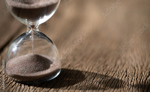 hourglass (sand clock) on the old wooden table, Hourglass as time passing concept for business deadline, Life-time passing concept, elapsed time concept, with copy space