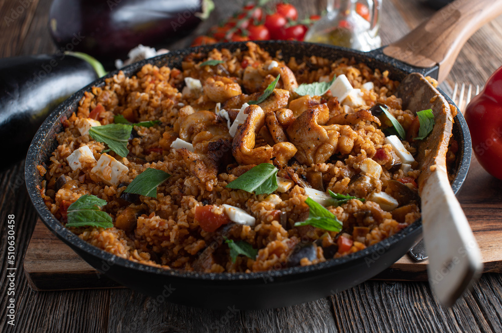 Mediterranean rice dish with eggplant, vegetables, chicken meat and feta cheese