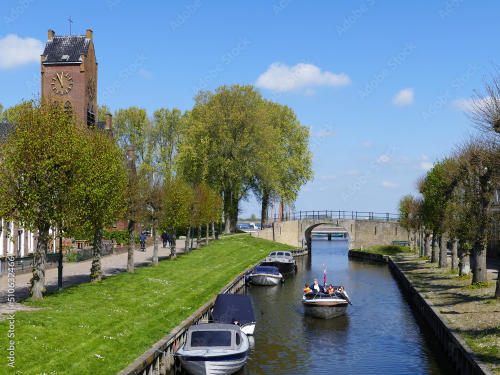 Canal through (Dutch) Sloten (Frisian) Sleat, Friesland, Netherlands, left the St Fredericus church