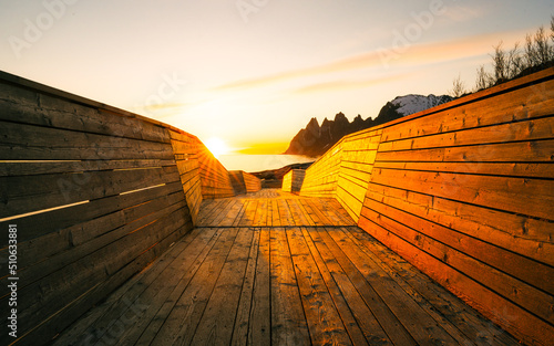 Tungeneset viewpoint in Senja, Norway at sunset with beautiful reflections of the Mountains and of the Devil teeth in the water creating a suggestive landscape photo