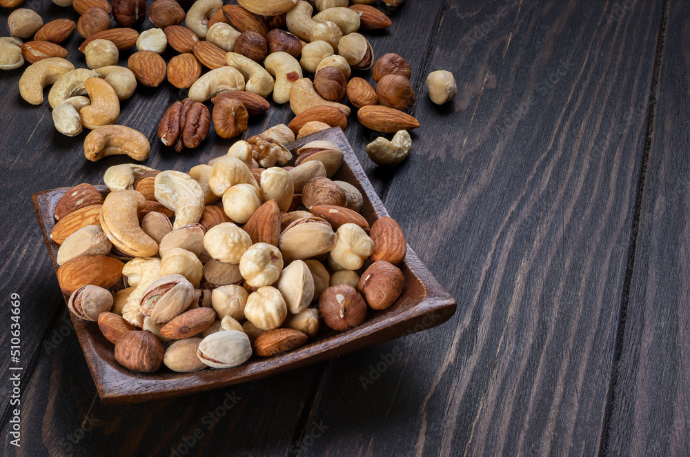 Cashew, almond, peanut, walnut nuts in a wooden bowl. Cashew, almond, peanut, walnut nuts in a wooden bowl.