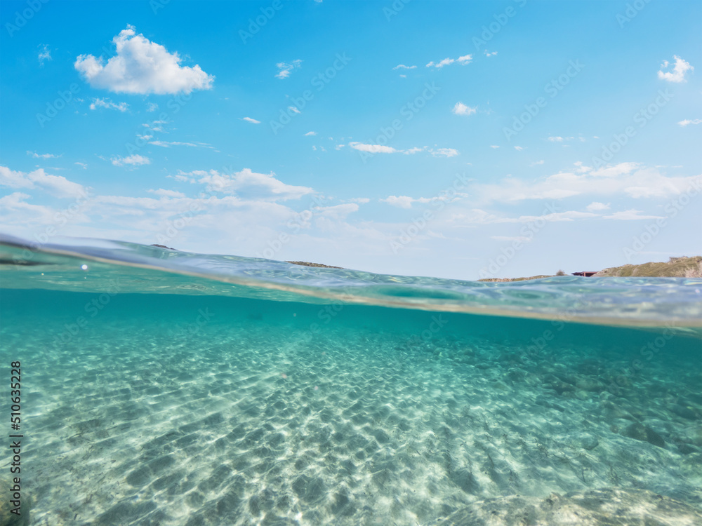 Split underwater view of La Speranza beaach clear water on a sunny day