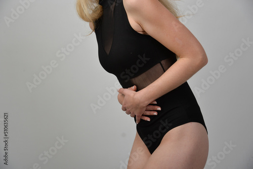 Frau mit bauchschmerzen hält hände an schlanken bauch taille sporltich kramp krämpfe menstruationsbeschwerden bauchkrämpfe bauchweh